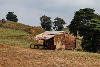 Abandoned house on field against sky