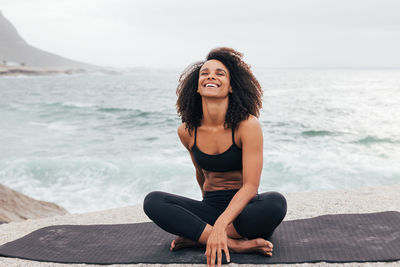 Portrait of young woman sitting at beach