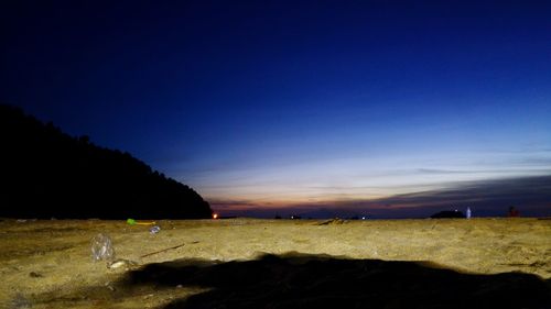 Silhouette man on sand against blue sky