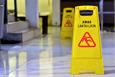 Close-up of yellow slippery floor sign