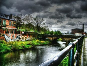 Bridge over river against cloudy sky