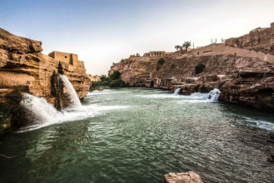 Scenic view of waterfall against sky