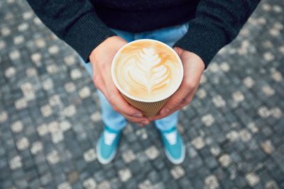 Low section of woman holding coffee in cup