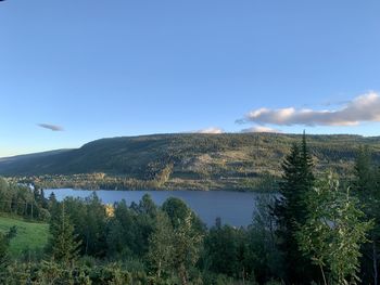 Scenic view of lake and mountains against blue sky