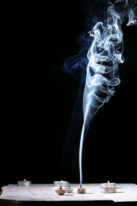 Close-up of cigarette on table against black background