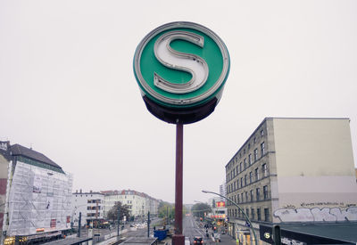 Letter s sign on road amidst buildings