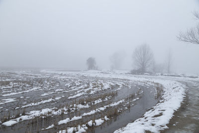 Scenic view of snow covered land against sky