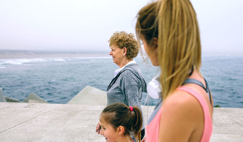 Girl with mother and grandmother walking on pier