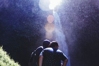 Friends in forest during sunny day