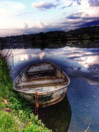 Boats in lake against cloudy sky