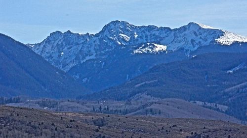 Scenic view of snow mountains against blue sky