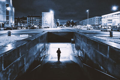 Rear view of man standing in city during winter