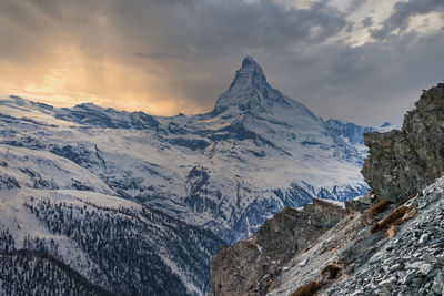 Magnificent matterhorn mountain in alps against cloudy sky during sunset