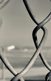 Close-up of metal fence against sky