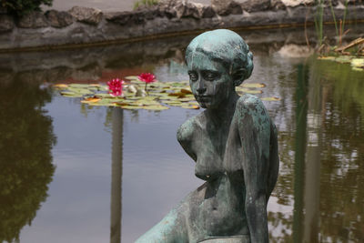 Statue by lake