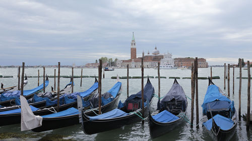 Boats moored in canal against sky