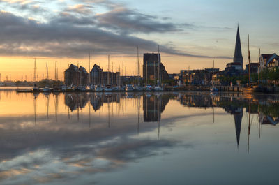 Reflection of city in water during sunset