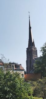 Low angle view of trees and buildings against sky