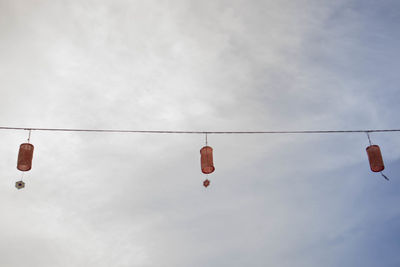 Low angle view of shoes hanging against sky