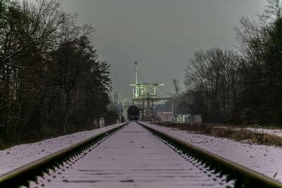 Surface level of railroad tracks against sky during winter