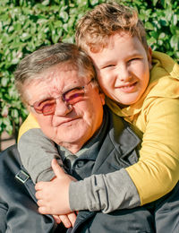 Portrait of smiling boy hugging his grandpa 