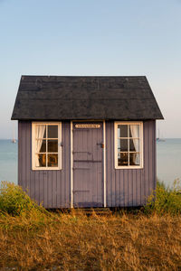 Exterior of old house on field against sky