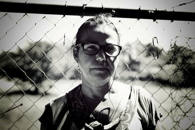 Portrait of mid adult man seen through chainlink fence