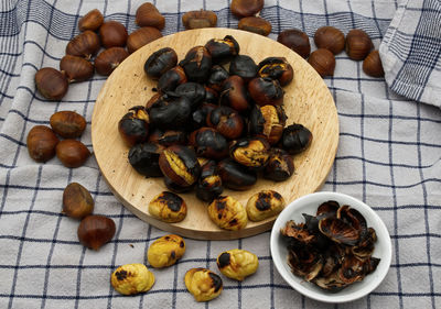 Fresh roasted chestnuts on a table with peels.