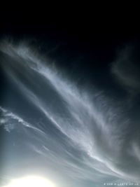 Low angle view of sunlight streaming through clouds