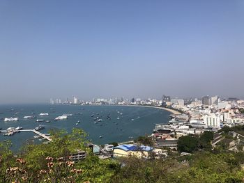 High angle view of city by sea against clear sky