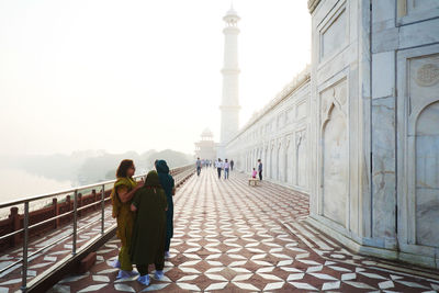 Rear view of people walking on bridge