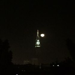 Illuminated clock tower in city at night