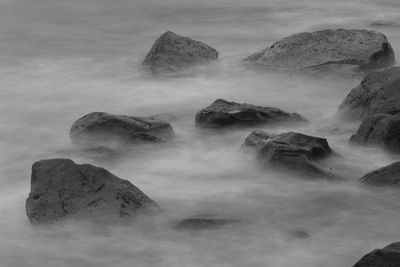 Scenic view of rocks in sea against sky