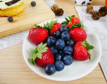 High angle view of strawberries and blueberries in plate on table