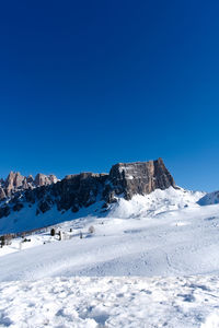 Scenic view of snowcapped mountains against clear blue sky