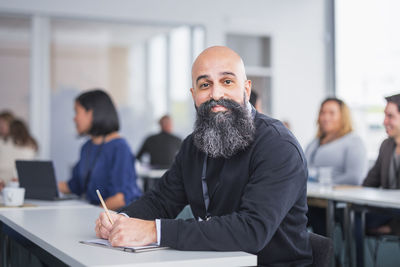 Portrait of smiling businessman sitting at desk