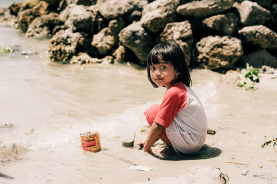 Portrait of young woman sitting at beach