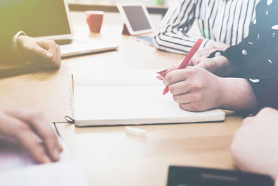 Cropped image of people working on table