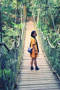 Portrait mid adult woman standing on footbridge