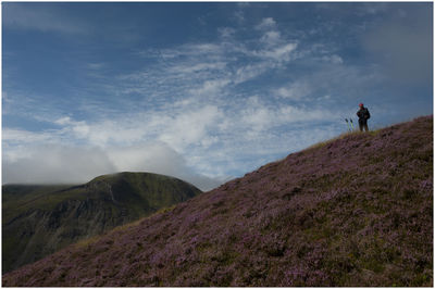 Man standing on mountain against sky