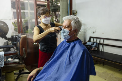 Senior man getting haircut in hair salon