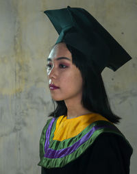 Portrait of beautiful woman standing against wall