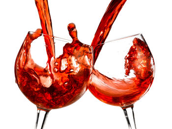 Close-up of red wine in glass against white background