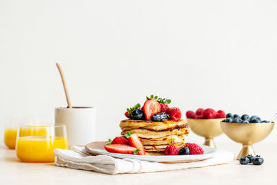 Close-up of breakfast sourdough pancakes on table against white background