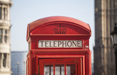 Close-up of red telephone booth against sky