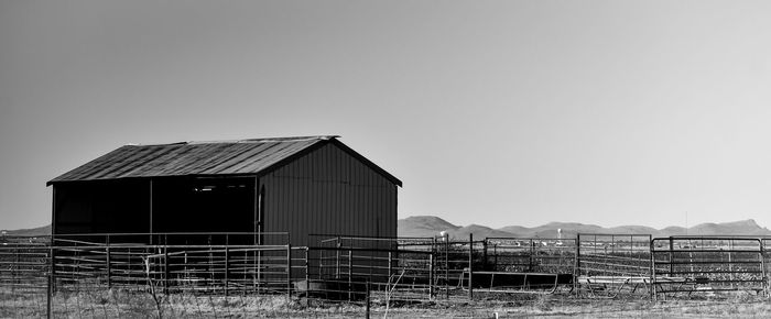 House by barn against clear sky