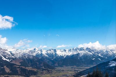 Scenic view of snow covered mountains against blue sky