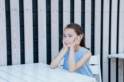 Portrait of smiling girl sitting at table