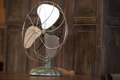 Close-up of old electric fan on table at home