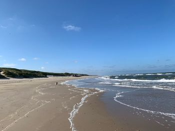 Scenic view of beach against blue sky